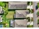 Bird's eye view of three homes showcasing well-maintained roofs and manicured lawns at 6136 Voyagers Pl, Apollo Beach, FL 33572