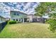 Spacious backyard featuring lush green grass, a covered patio, and secure fencing at 6136 Voyagers Pl, Apollo Beach, FL 33572