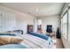 Bright bedroom featuring neutral walls, plush carpet, and a comfortable bed, accompanied by a home office setup and large windows at 6136 Voyagers Pl, Apollo Beach, FL 33572
