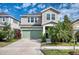 Charming two-story home with well-manicured lawn, featuring an attached garage and covered front porch at 6136 Voyagers Pl, Apollo Beach, FL 33572