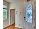 Light-filled entryway featuring a stylish front door with a patterned glass insert and wood floors at 6136 Voyagers Pl, Apollo Beach, FL 33572