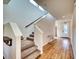 Bright foyer featuring wood floors, carpeted stairs, and a decorative entry door at 6136 Voyagers Pl, Apollo Beach, FL 33572