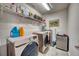 Functional laundry room featuring modern washer and dryer set with overhead shelving and a compact design at 6136 Voyagers Pl, Apollo Beach, FL 33572