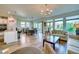 Open-concept living room with wood floors, modern lighting, and sliding glass doors to the lanai at 6136 Voyagers Pl, Apollo Beach, FL 33572