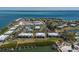 Panoramic aerial view of waterfront homes, docks, tennis courts, swimming pool, and the scenic bay at 6200 Flotilla Dr # 245, Holmes Beach, FL 34217