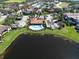 An aerial view showcases a community pool and clubhouse next to a picturesque lake, surrounded by well-manicured lawns at 6208 Signature Pointe Ln, Bradenton, FL 34210