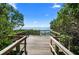 Scenic view from the end of a wooden boardwalk surrounded by lush greenery and leading to the ocean at 6208 Signature Pointe Ln, Bradenton, FL 34210