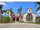 Community clubhouse with a tile roof, stucco walls, and tropical landscaping at 6208 Signature Pointe Ln, Bradenton, FL 34210