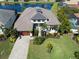 Beautiful home with tropical plants, well manicured lawn and a fountain in the lake behind the house at 6208 Signature Pointe Ln, Bradenton, FL 34210