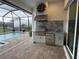 Covered outdoor kitchen featuring stainless steel appliances and sink with a beautiful backyard pool view at 6208 Signature Pointe Ln, Bradenton, FL 34210