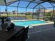 Enclosed pool area overlooking a lake, with outdoor dining furniture at 6208 Signature Pointe Ln, Bradenton, FL 34210