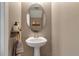 Cozy half-bath features a pedestal sink, decorative mirror, and rustic-chic decor at 6265 Fairmont Ln, Palmetto, FL 34221