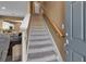 Entryway featuring carpeted stairs, a wooden banister, and views into the kitchen and living area at 6265 Fairmont Ln, Palmetto, FL 34221