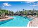 A serene pool with sun loungers is surrounded by lush landscaping and palm trees in this beautiful community at 6265 Fairmont Ln, Palmetto, FL 34221