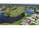 Aerial view of a residential community with a golf course, water features, pools, and verdant landscaping at 6514 Stone River Rd, Bradenton, FL 34203