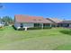 Well-maintained backyard with lush lawn and mature landscaping with a tile roof at 6514 Stone River Rd, Bradenton, FL 34203