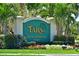 Entrance sign to Tara Golf & Country Club surrounded by lush landscaping, tropical plants, and colorful flowers at 6514 Stone River Rd, Bradenton, FL 34203