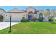Charming front exterior features a well-maintained lawn, beautiful landscaping, and a two-car garage at 6514 Stone River Rd, Bradenton, FL 34203