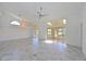 Spacious living room boasts tile floors, a ceiling fan, and sliding doors leading to a screened lanai at 6514 Stone River Rd, Bradenton, FL 34203