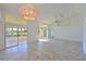 Bright and airy living space featuring tile flooring, large sliding glass doors, and modern chandelier at 6514 Stone River Rd, Bradenton, FL 34203