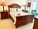 Cozy bedroom featuring a wooden bed frame, two bedside tables with lamps, and a turquoise chair in the corner at 6707 Stone River Rd # 105, Bradenton, FL 34203