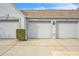 Three garages with unit numbers offer ample parking in front of a building with a well-manicured shrub and blue sky at 6707 Stone River Rd # 105, Bradenton, FL 34203