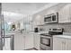 Well-lit kitchen featuring stainless steel appliances, light countertops, and bright white cabinetry at 6707 Stone River Rd # 105, Bradenton, FL 34203