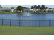 Picturesque lake view framed by a black fence and bordered with green grass. Houses are in the background at 6707 Stone River Rd # 105, Bradenton, FL 34203