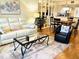 Inviting living room with a white leather sofa, glass coffee table, and hardwood floors, open to the dining area and kitchen at 6707 Stone River Rd # 105, Bradenton, FL 34203