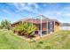 A spacious backyard shows a screened-in patio and lush greenery providing an outdoor oasis at 7118 42Nd E Ct, Sarasota, FL 34243