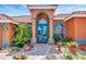 Charming home entrance with a colorful exterior, arched doorway, and vibrant landscaping at 7118 42Nd E Ct, Sarasota, FL 34243