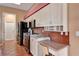Efficient kitchen featuring black appliances, tile backsplash, and a built in desk at 7118 42Nd E Ct, Sarasota, FL 34243
