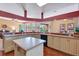Open-concept kitchen with an island, stainless steel appliances, and light wood cabinetry at 7118 42Nd E Ct, Sarasota, FL 34243