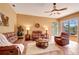 Cozy living room featuring comfortable seating, a ceiling fan, and access to the patio at 7118 42Nd E Ct, Sarasota, FL 34243