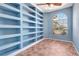 Office space featuring built-in bookshelves, a ceiling fan, and a sunny arched window at 7118 42Nd E Ct, Sarasota, FL 34243