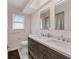 Bathroom featuring double sinks, gray cabinets, and wood look floors at 7211 Antigua Pl, Sarasota, FL 34231
