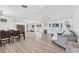 Open-concept living room with dining area, wood-look floors, and lots of natural light at 7211 Antigua Pl, Sarasota, FL 34231