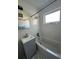 Bright bathroom features a gray vanity, tub with shower, and a window for natural light at 728 41St St St, Sarasota, FL 34234