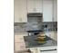 A well-lit kitchen with white cabinetry, stainless steel appliances, and a unique backsplash at 728 41St St St, Sarasota, FL 34234