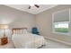 Cozy bedroom featuring a ceiling fan, natural light from the window, and comfortable blue armchair at 7424 Ridgelake Cir, Bradenton, FL 34203