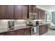 Kitchen features stainless appliances, granite counters, dark cabinetry and a breakfast bar seating area at 7424 Ridgelake Cir, Bradenton, FL 34203