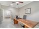 Bright office space features statement wood desk, chair, ceiling fan, and adjacent sitting room at 7424 Ridgelake Cir, Bradenton, FL 34203