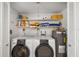 Neat laundry closet featuring a washer, dryer, water heater, and shelving for storage at 7460 Mariana Dr, Sarasota, FL 34231