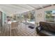 Well lit sunroom that includes a dining table, living room seating, and windows to the backyard and pool area at 7460 Mariana Dr, Sarasota, FL 34231