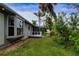 Back of home with small porch overlooking green backyard surrounded by trees and lush landscaping at 800 Everest Rd, Venice, FL 34293
