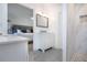 Bright bathroom with modern vanity, gray tile, and shower with pebble floor at 800 Everest Rd, Venice, FL 34293