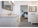 Bright bathroom with modern vanity, gray tile, and view into the bedroom at 800 Everest Rd, Venice, FL 34293
