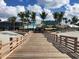 Wooden boardwalk leads to sandy beach with restaurant and tiki bar, perfect for relaxing and enjoying the coastal lifestyle at 800 Everest Rd, Venice, FL 34293