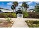 Inviting entrance to a building, surrounded by lush landscaping and palm trees at 800 Everest Rd, Venice, FL 34293