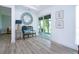 Hallway featuring a large round mirror, a sliding glass door leading to the screened lanai, and wood-look floors at 800 Everest Rd, Venice, FL 34293